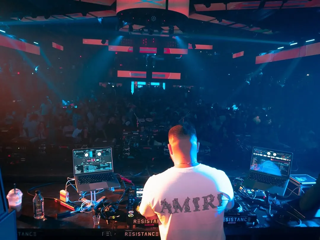 Wide view from behind the booth across an arena crowd, LED screen reading Miami. Opens larger.